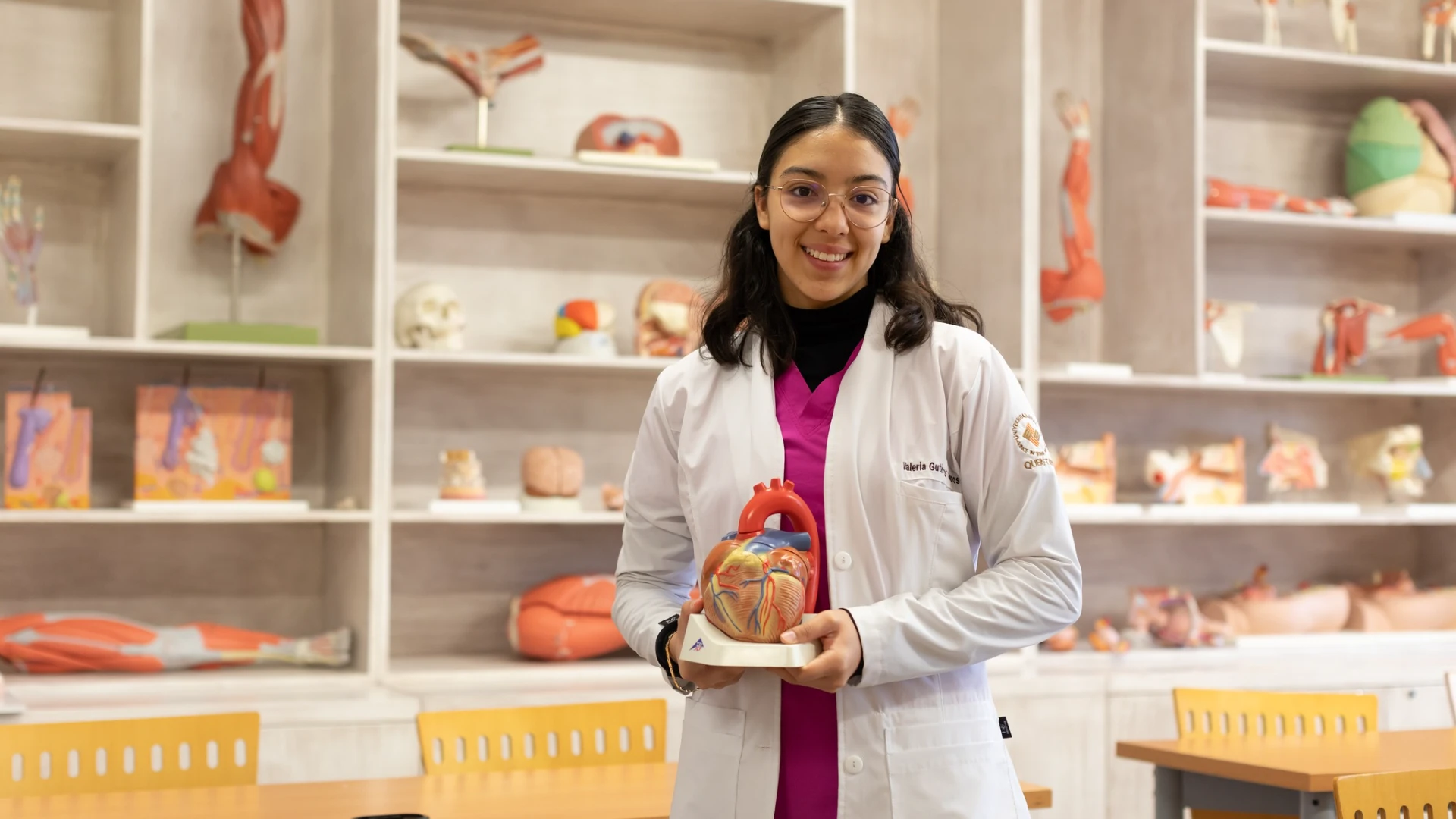 Estudiante de medicina de la Anáhuac en un laboratorio sosteniendo una maqueta de un corazón