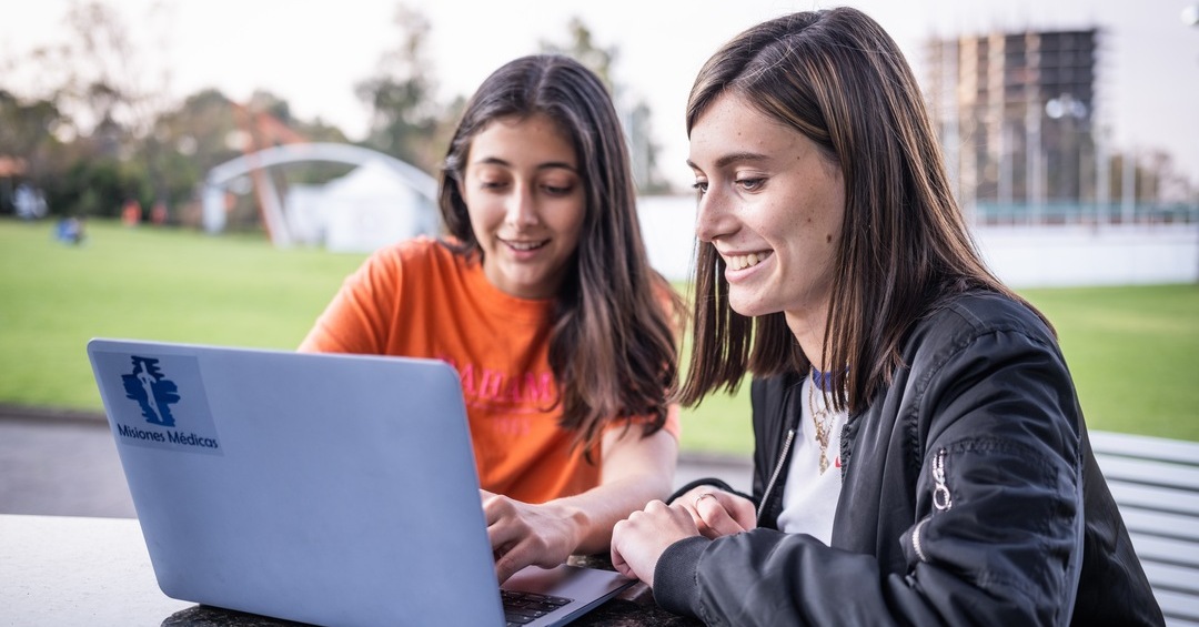 alumnas trabajando en campus con computadora