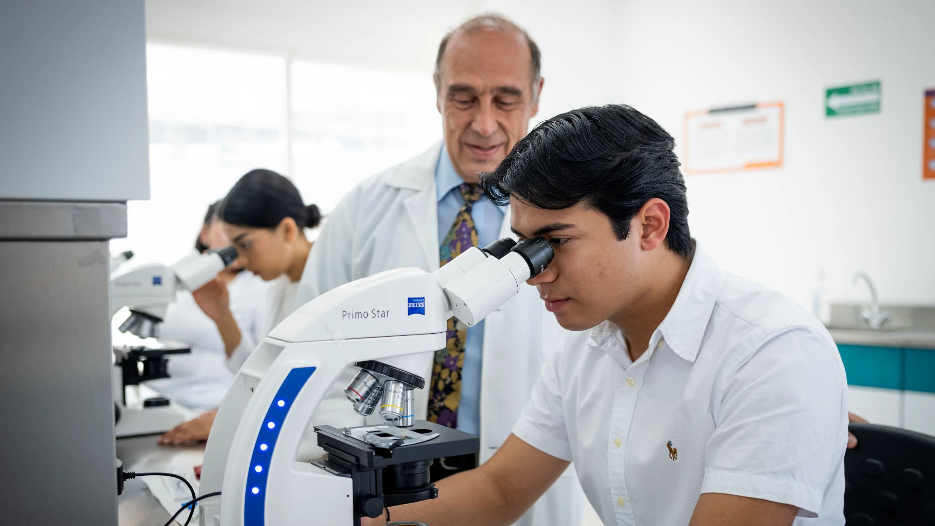 Estudiante de ingeniería quimica usando microscopio en clase anahuac