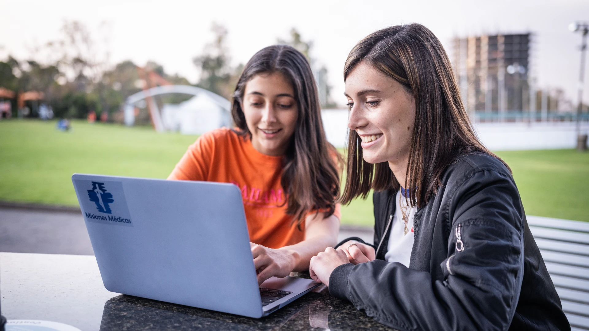 Estudiantes anahuac sentados en campus en sus laptops