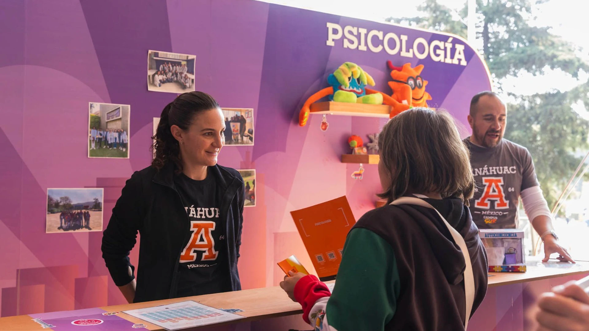 Estudiante pidiendo informes en un stand de carrera de psicología, porque estudiar psicología