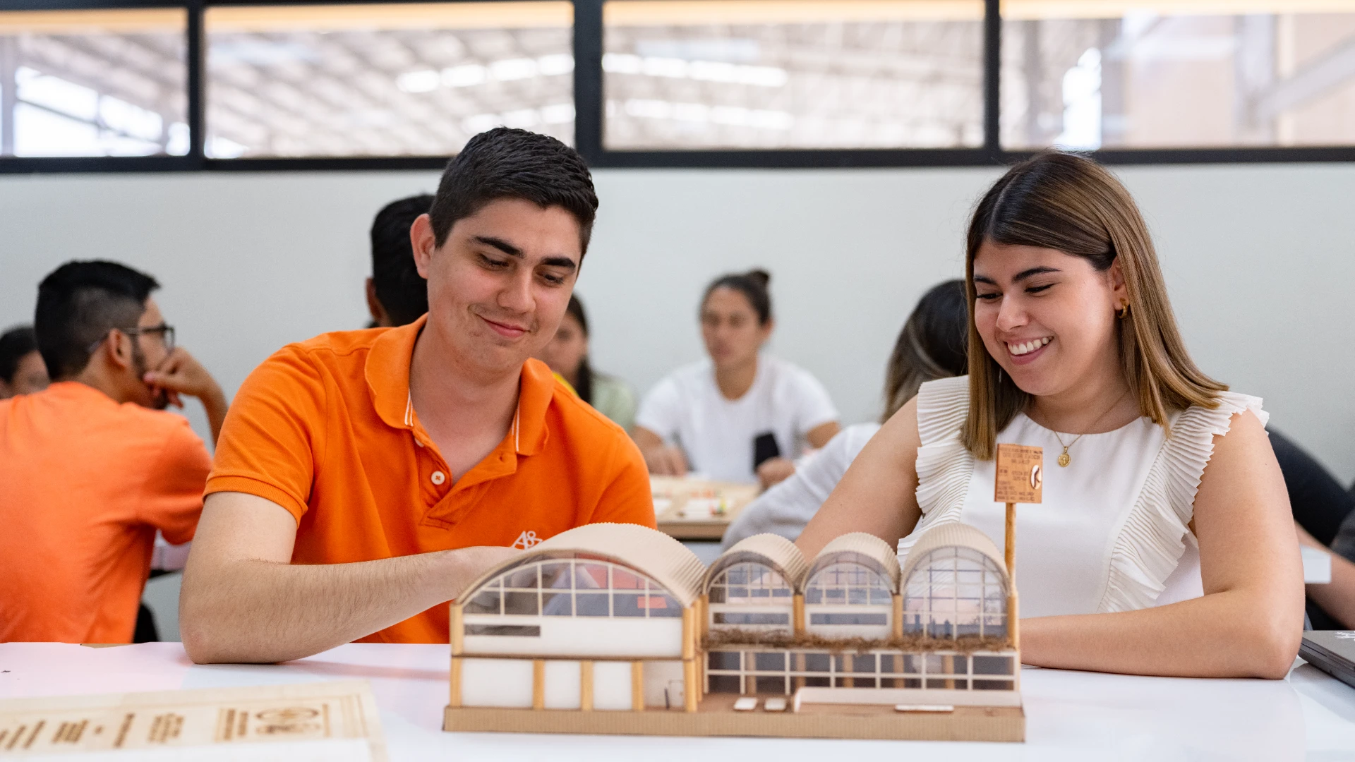 Estudiantes de arquitectura construyendo una maqueta de urbanismo sostenible en clase