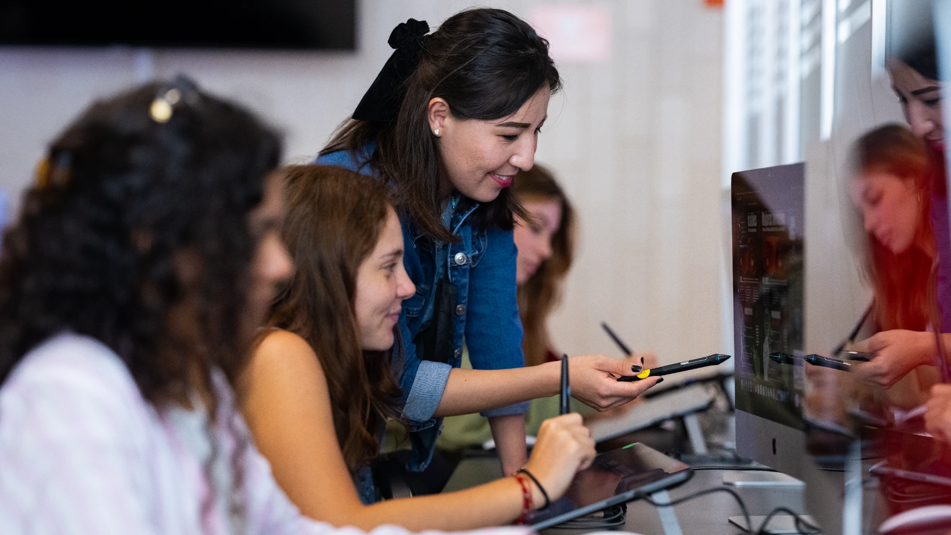 Estudiantes en clase de diseño multimedia dibujando en tabletas