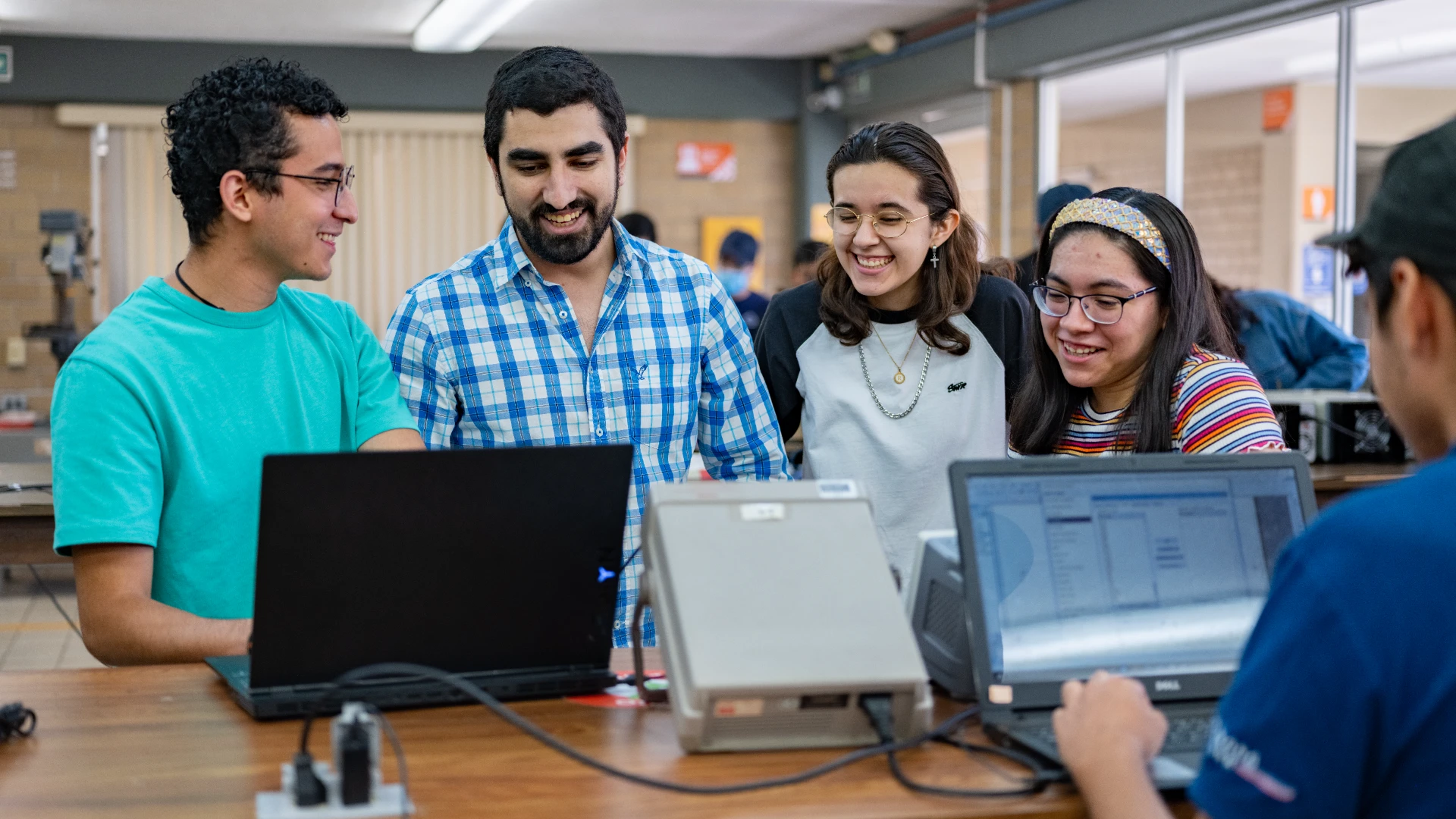 Estudiantes de ingeniería en sistemas viendo el equipo de computo disponible en el laboratorio anahuac