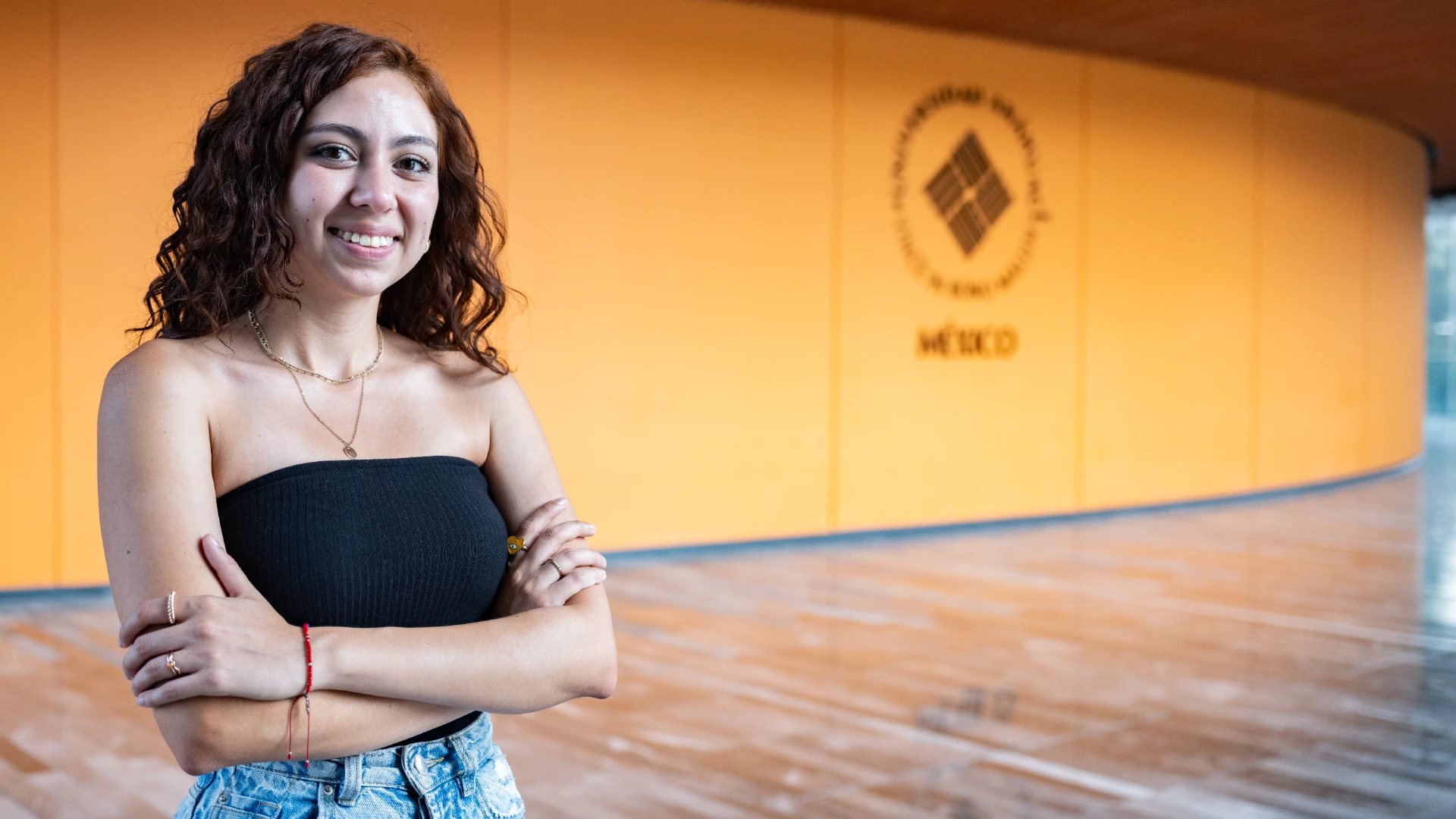 Estudiante anahuac sonriendo frente a teartro en campus