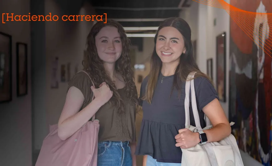 Par de estudiantes de la Red de Universidades Anáhuac sonriendo en pasillos del campus