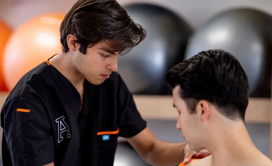 Estudiante de terapia física realizando un ejercicio práctico en el consultorio clínico de la Anáhuac