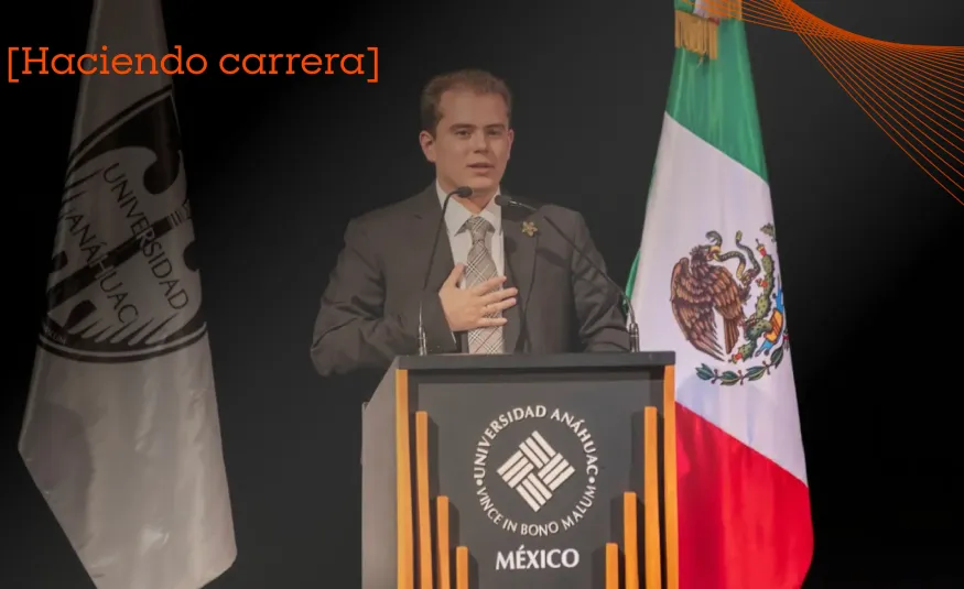 Estudiante de la Anáhuac trajeado dando un discurso sobre qué son las políticas públicas en un estrado