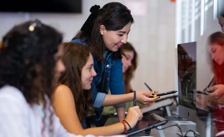 Estudiantes en clase de diseño multimedia dibujando en tabletas