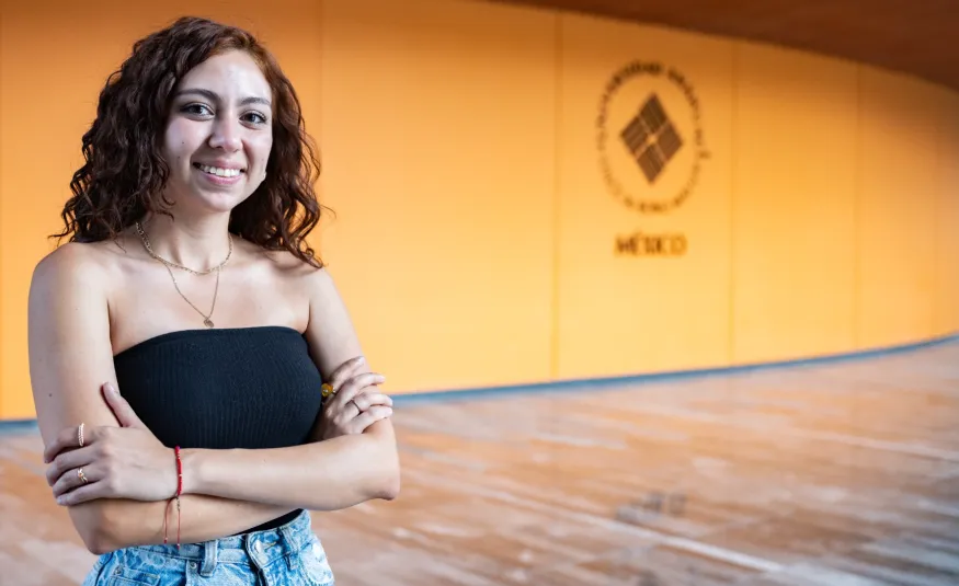 Estudiante anahuac sonriendo frente a teartro en campus