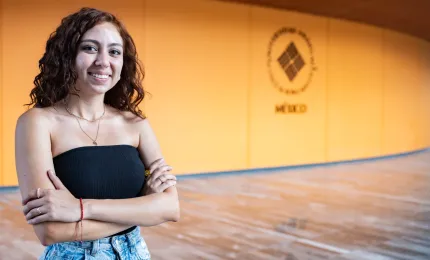 Estudiante anahuac sonriendo frente a teartro en campus