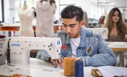 Estudiante de diseño de moda cosiendo una prenda con textiles sustentables