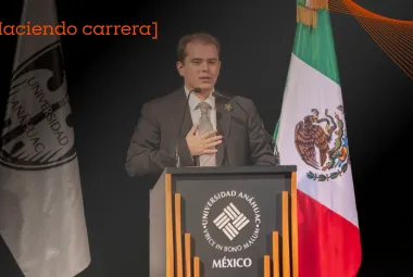 Estudiante de la Anáhuac trajeado dando un discurso sobre qué son las políticas públicas en un estrado