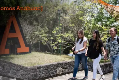 estudiantes de la universidad anahuac caminando por el campus con arboles al fondo