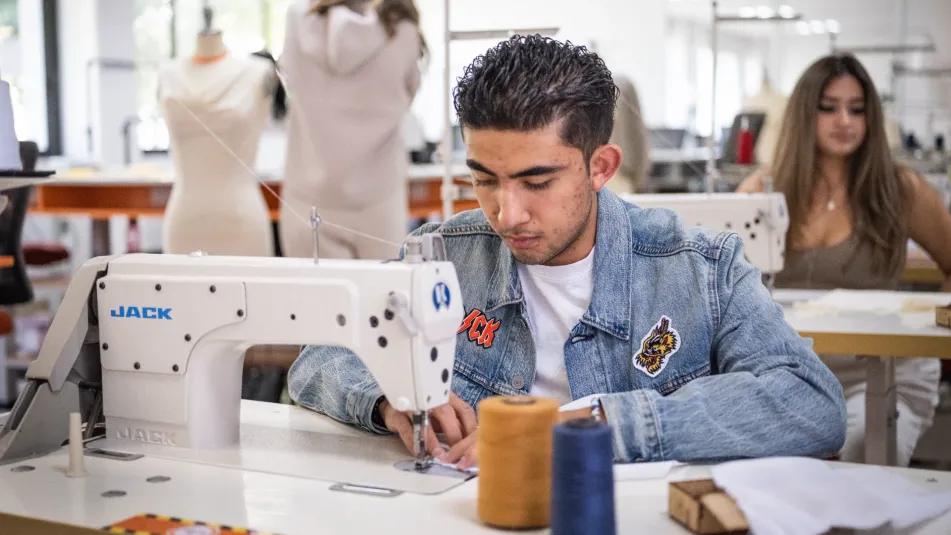 Estudiante de diseño de moda cosiendo una prenda con textiles sustentables