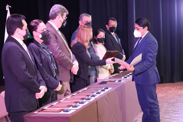 Alumno de universidad recibiendo reconocimiento de las autoridades académicas del IEST Anáhuac.