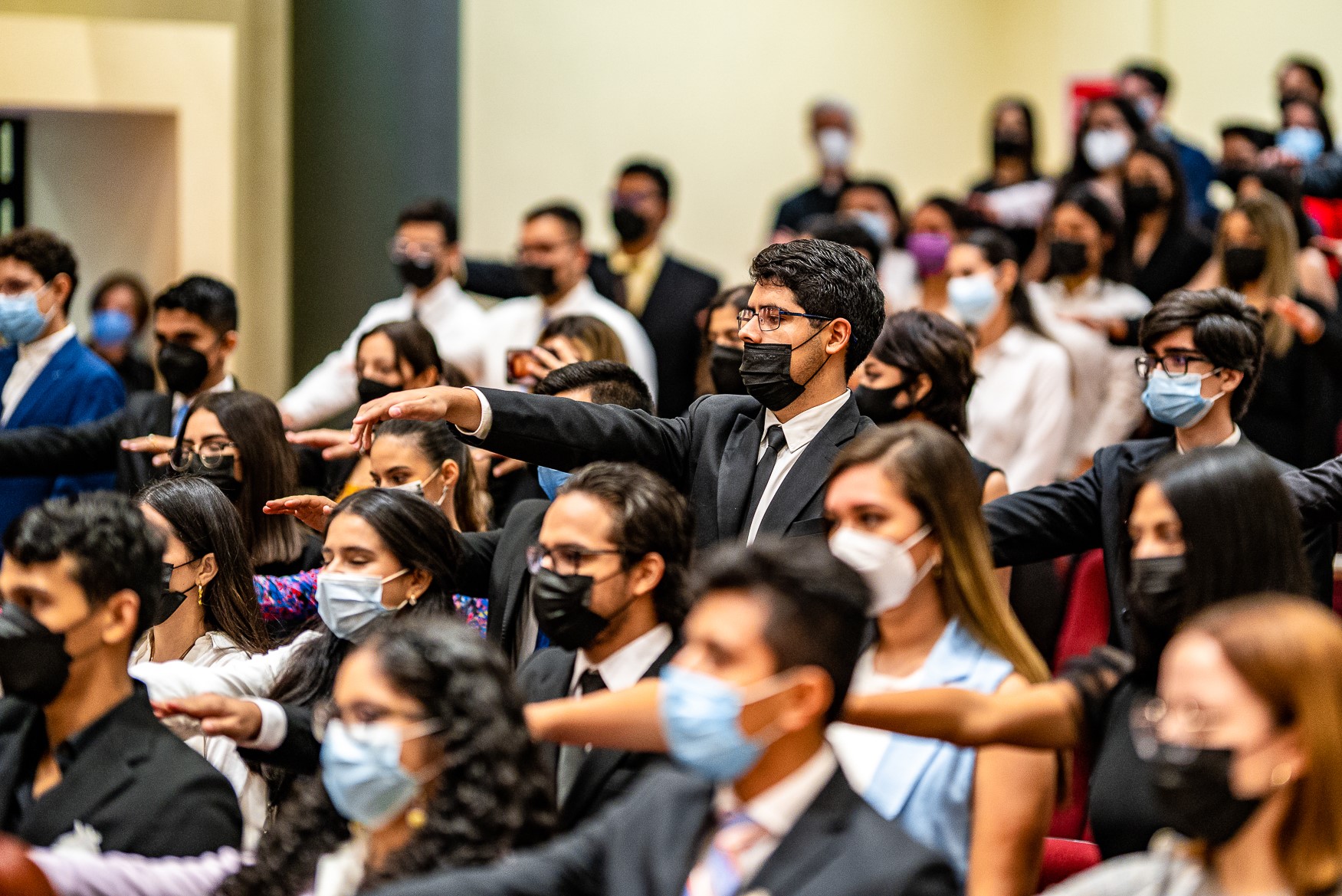 Alumnos de saco y vestido, tomando protesta en el auditorio David Gómez.