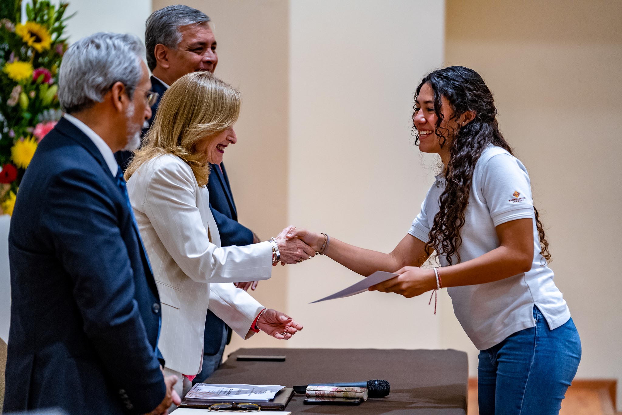 Muchacha de preparatoria recibiendo reconocimiento de nuestra rectora.