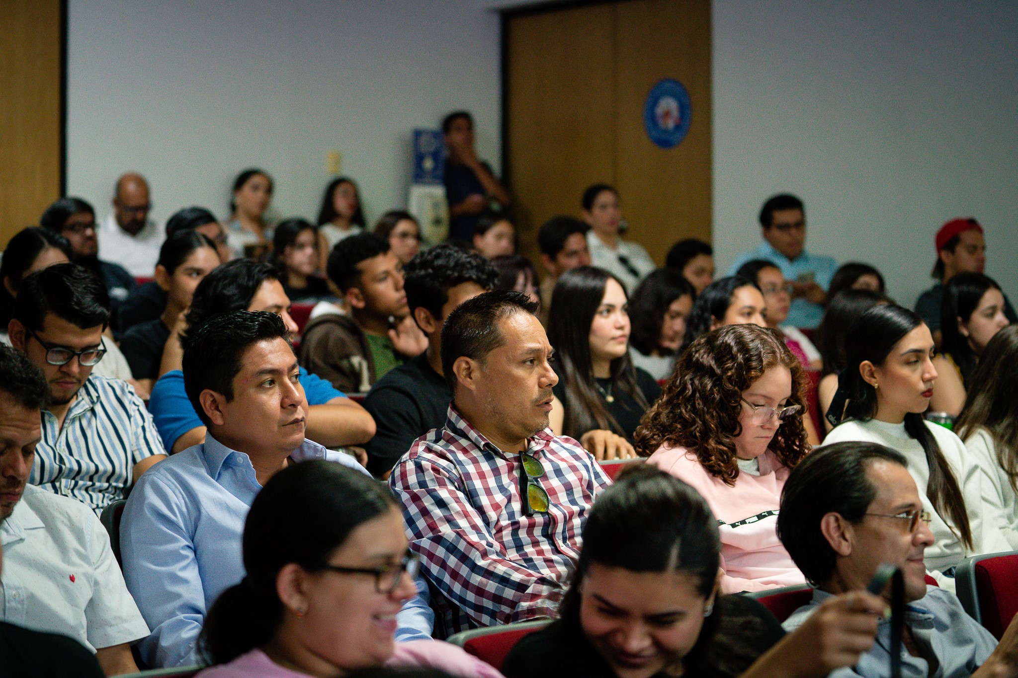 Alumnos de Derecho, sentados en el auditorio C.P. Jesús Rodríguez, prestando atención a conferencia.
