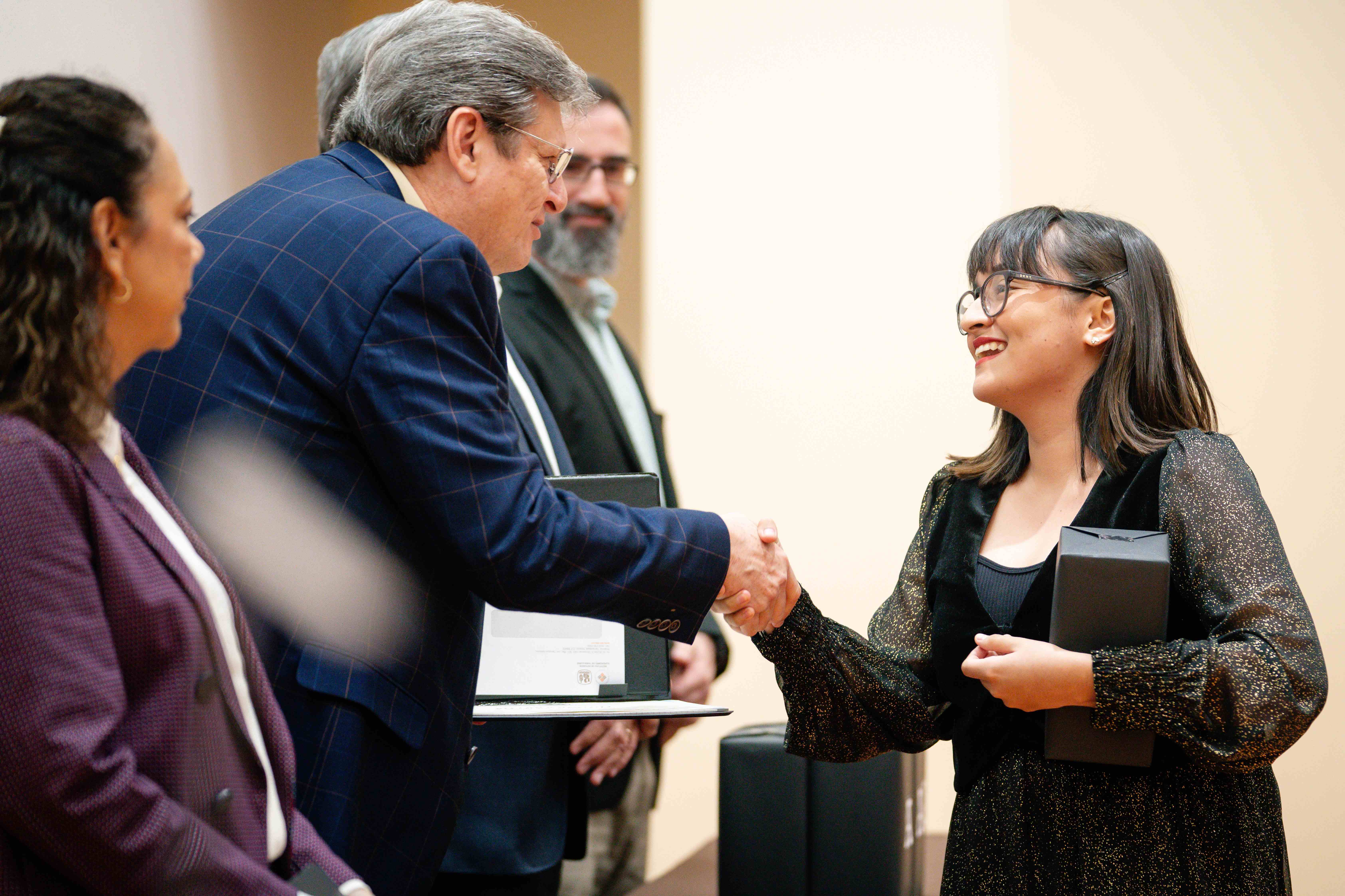 Alumna recibe felicitación del Mtro. Basilio Kot.