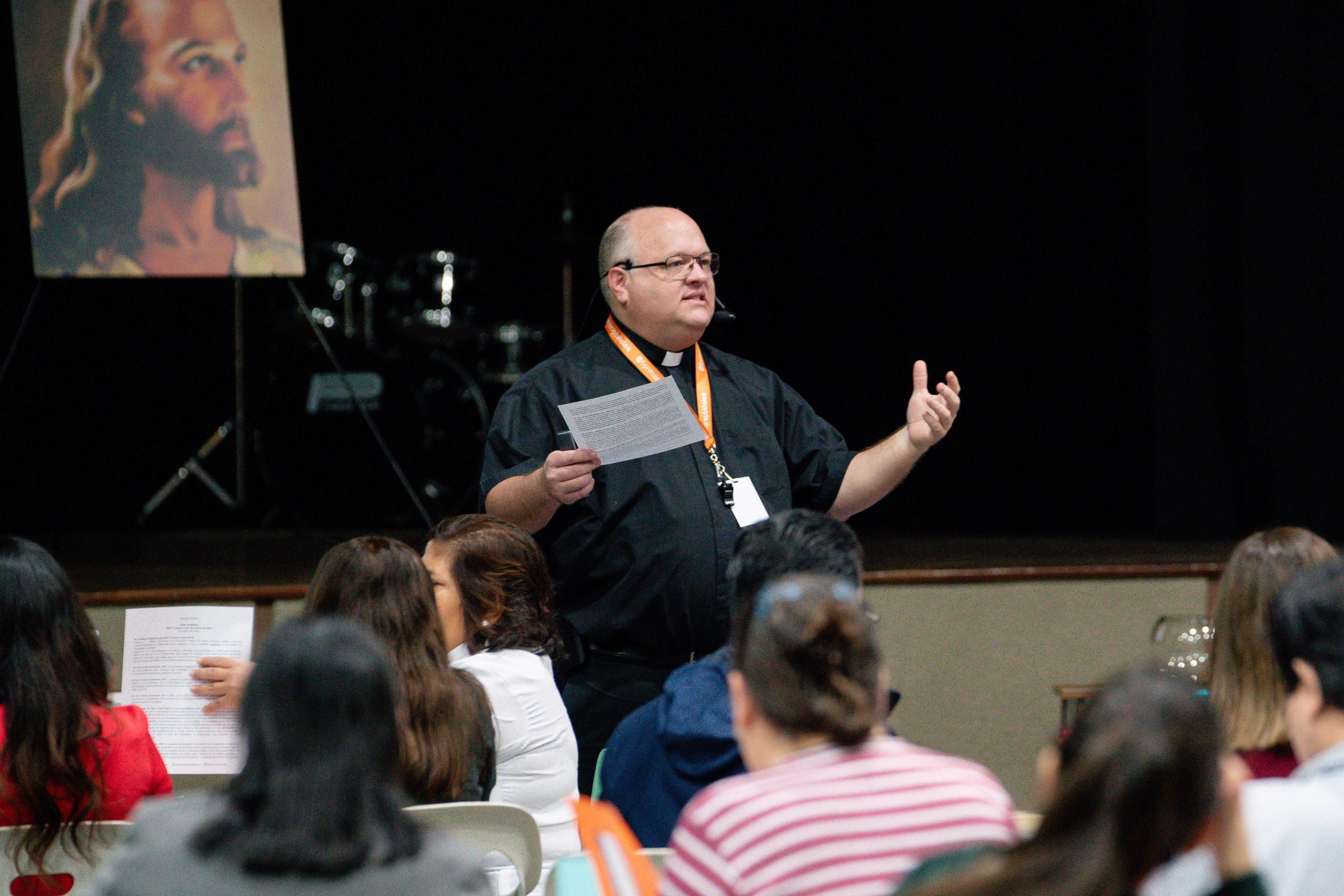 Padre Pacannins ofreciendo una charla.