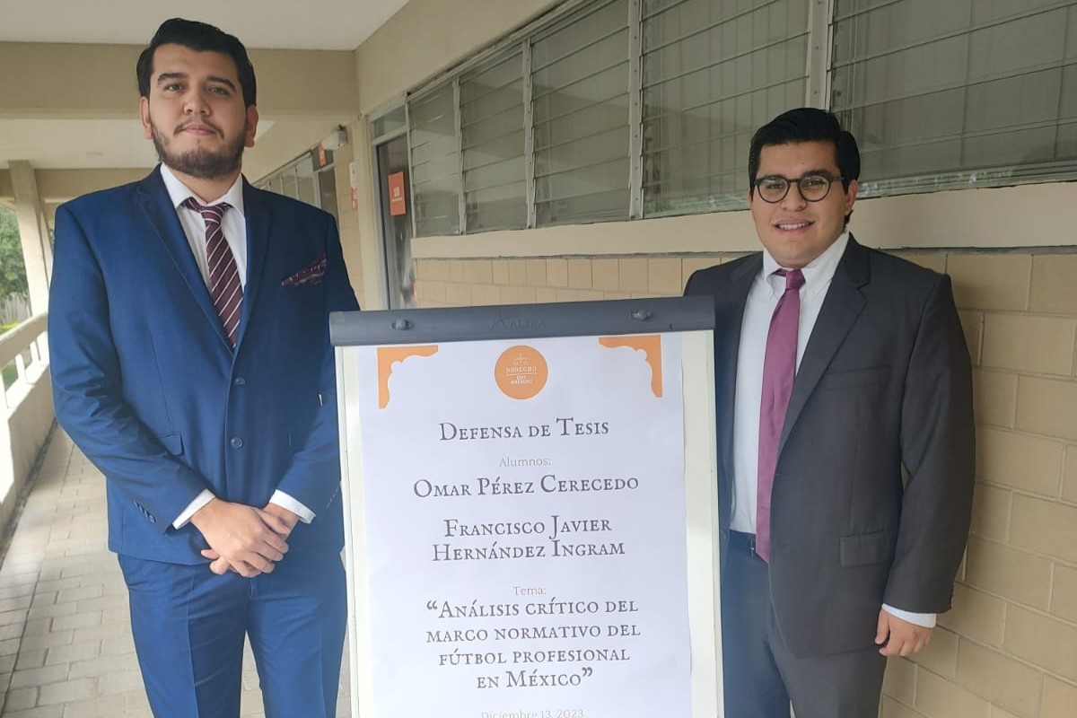 Alumnos de Derecho, en traje, posando afuera de la Sala de Juicios Orales.