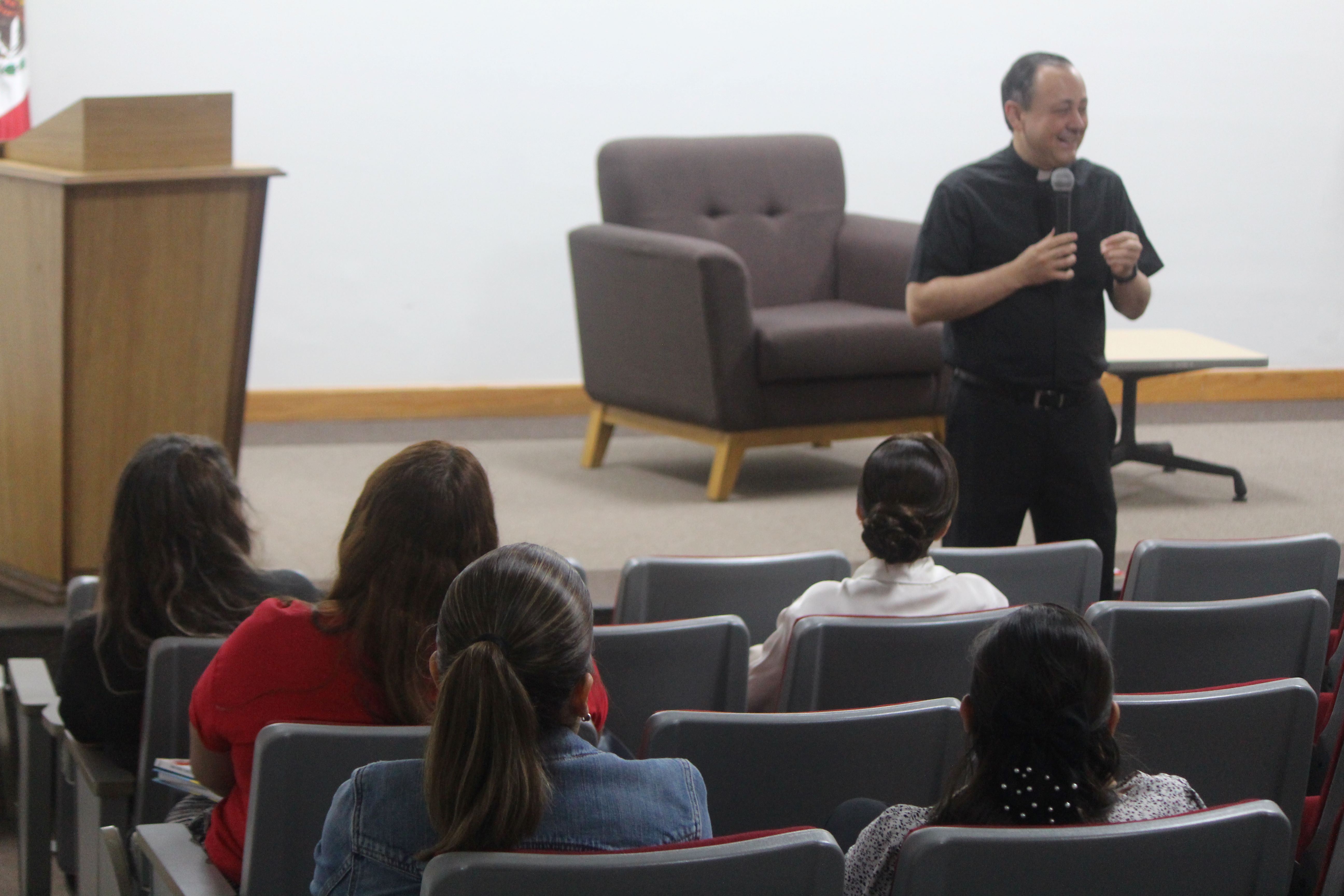 El padre Güémez delante de un grupo de profesores, en el auditorio C.P. Jesús Rodríguez.