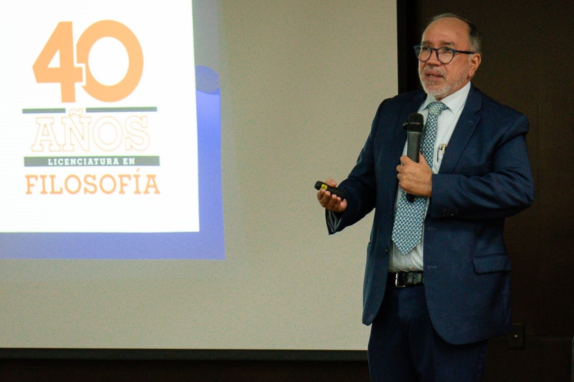 El Dr. Solís explicando, acompañado del logotipo de los 40 años de Filosofía.