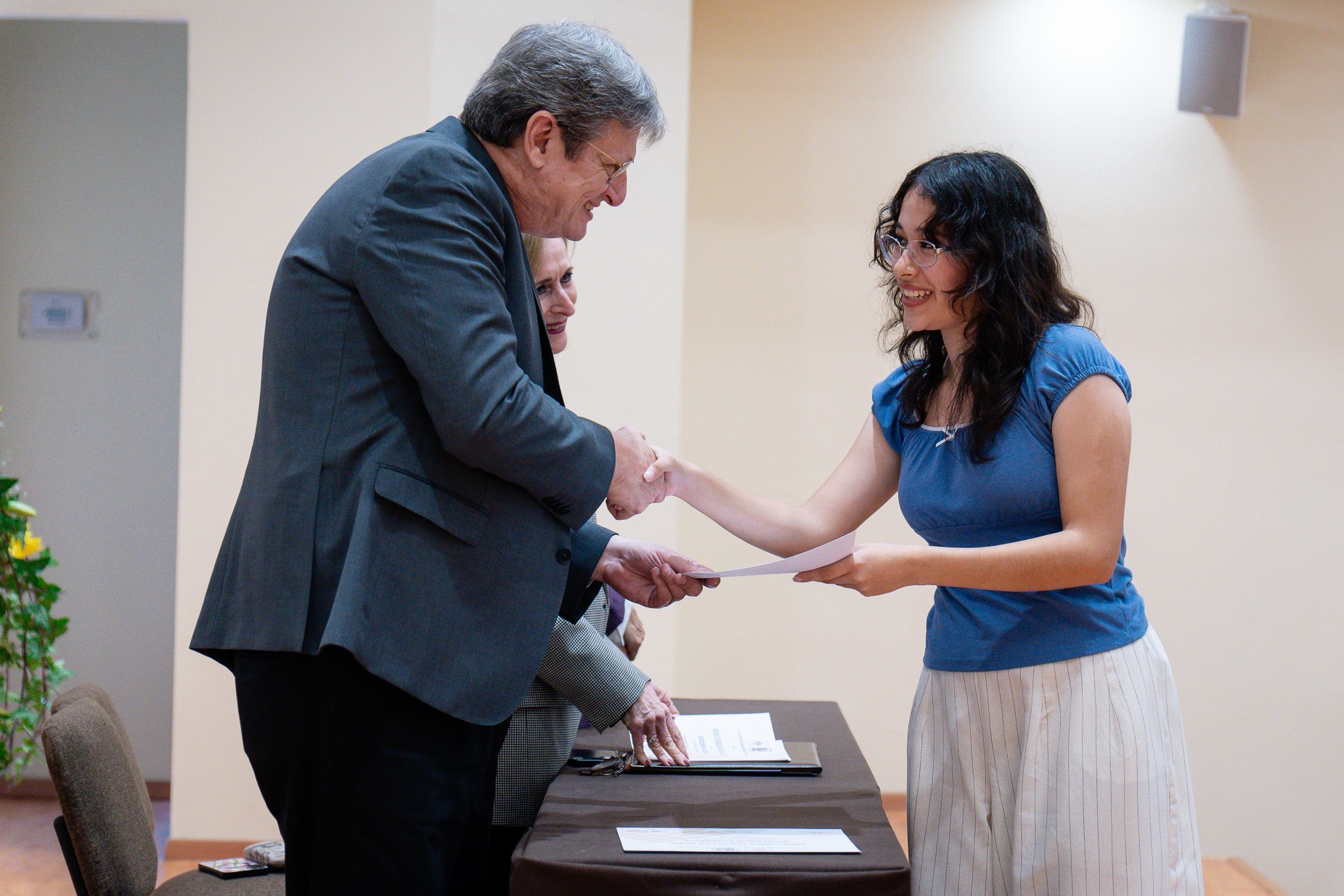 El Mtro. Basilio Kot felicita a una alumna, durante la entrega de reconocimientos de Excelencia de Universidad.