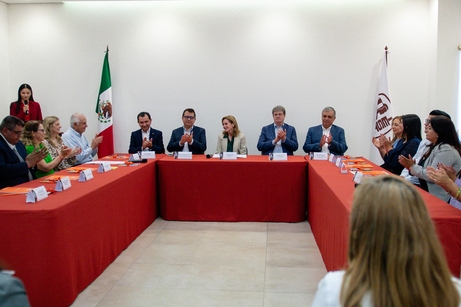Autoridades aplauden, sentadas en la Sala de Juntas de la Rectoría, en compañía de prestadores de servicio social.