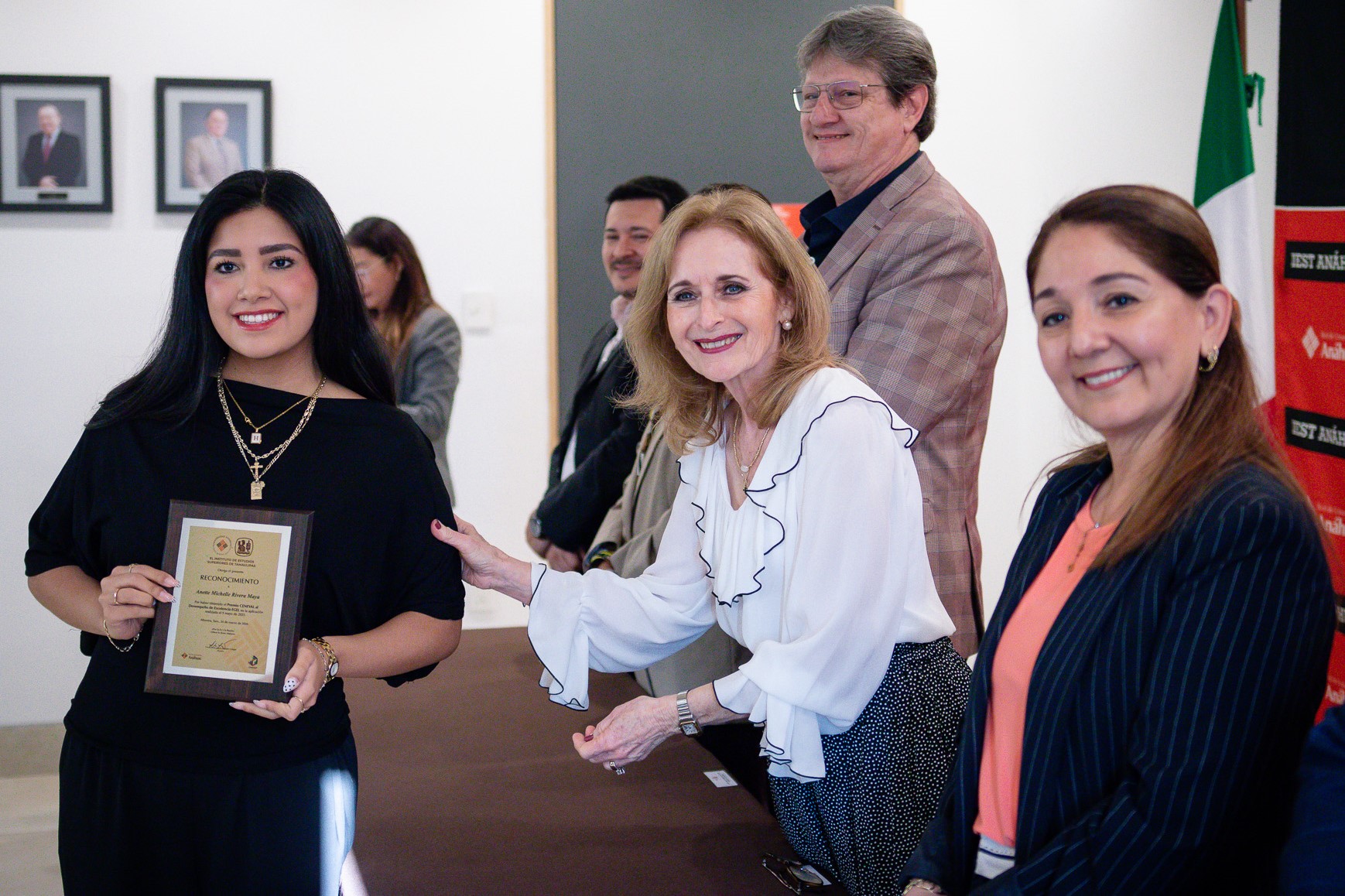 Recién egresada recibe su placa del Premio CENEVAL, en la Sala de Juntas de Rectoría, el 24 de marzo de 2026.