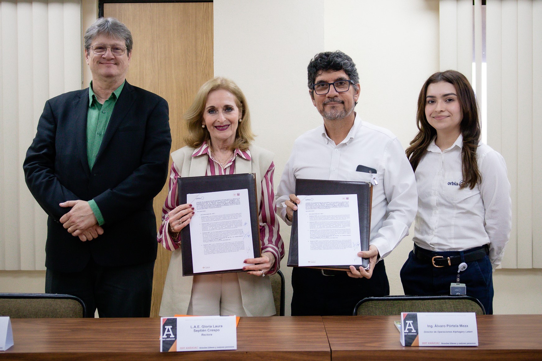 La Rectora y el representante de ORBIA sostienen el convenio que firmaron.