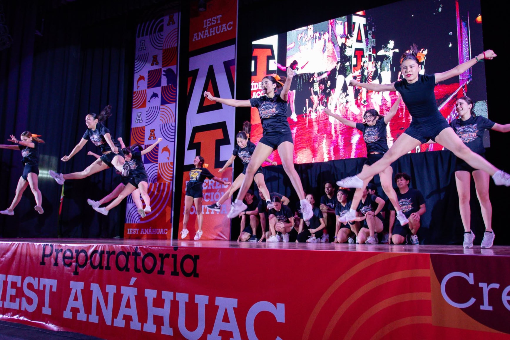 Alumnas del grupo de animación saltan en el escenario, en la BIP.