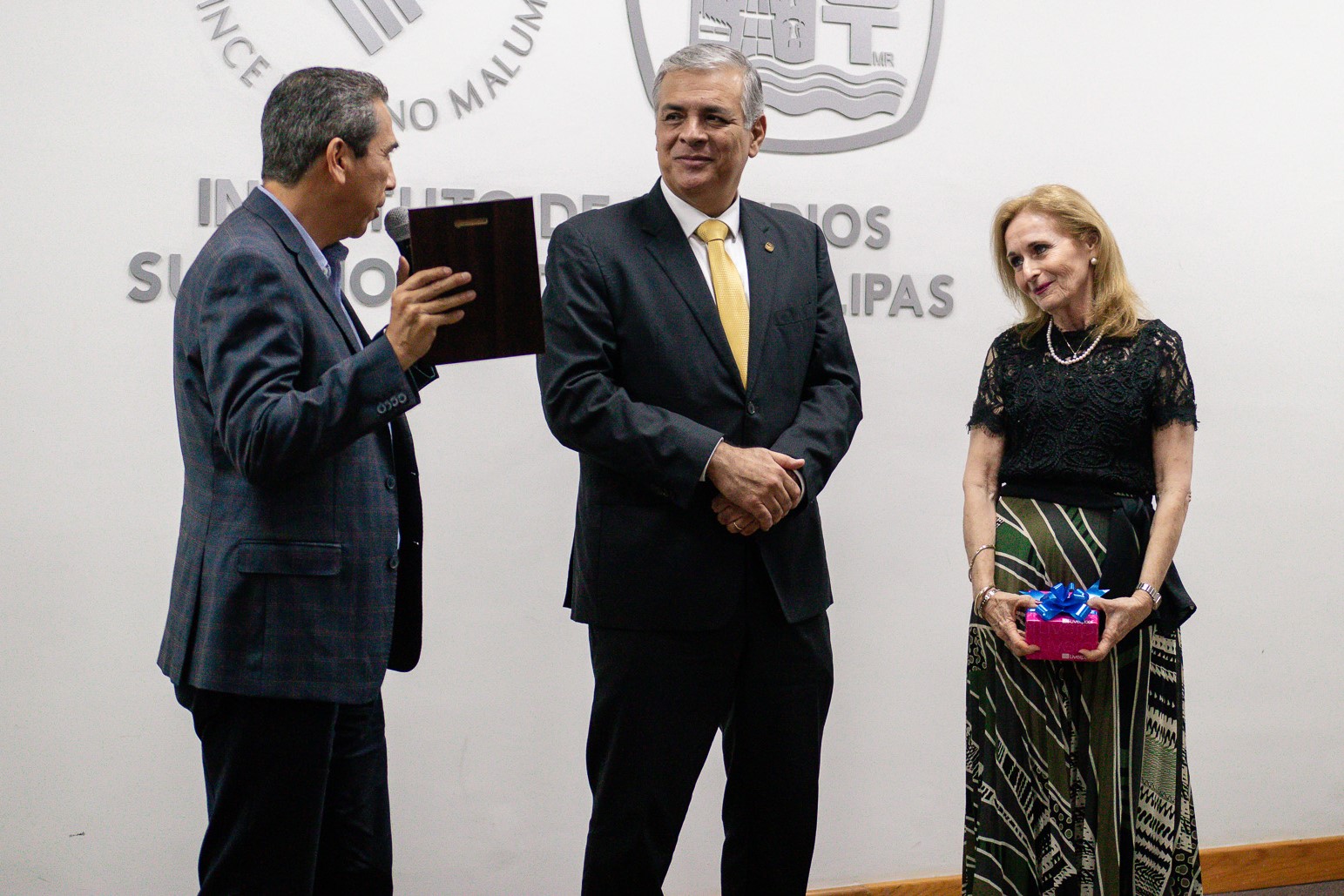 Rubén Zárate entrega una placa de reconocimiento al Mtro. Meléndez. Gloria Septién observa.