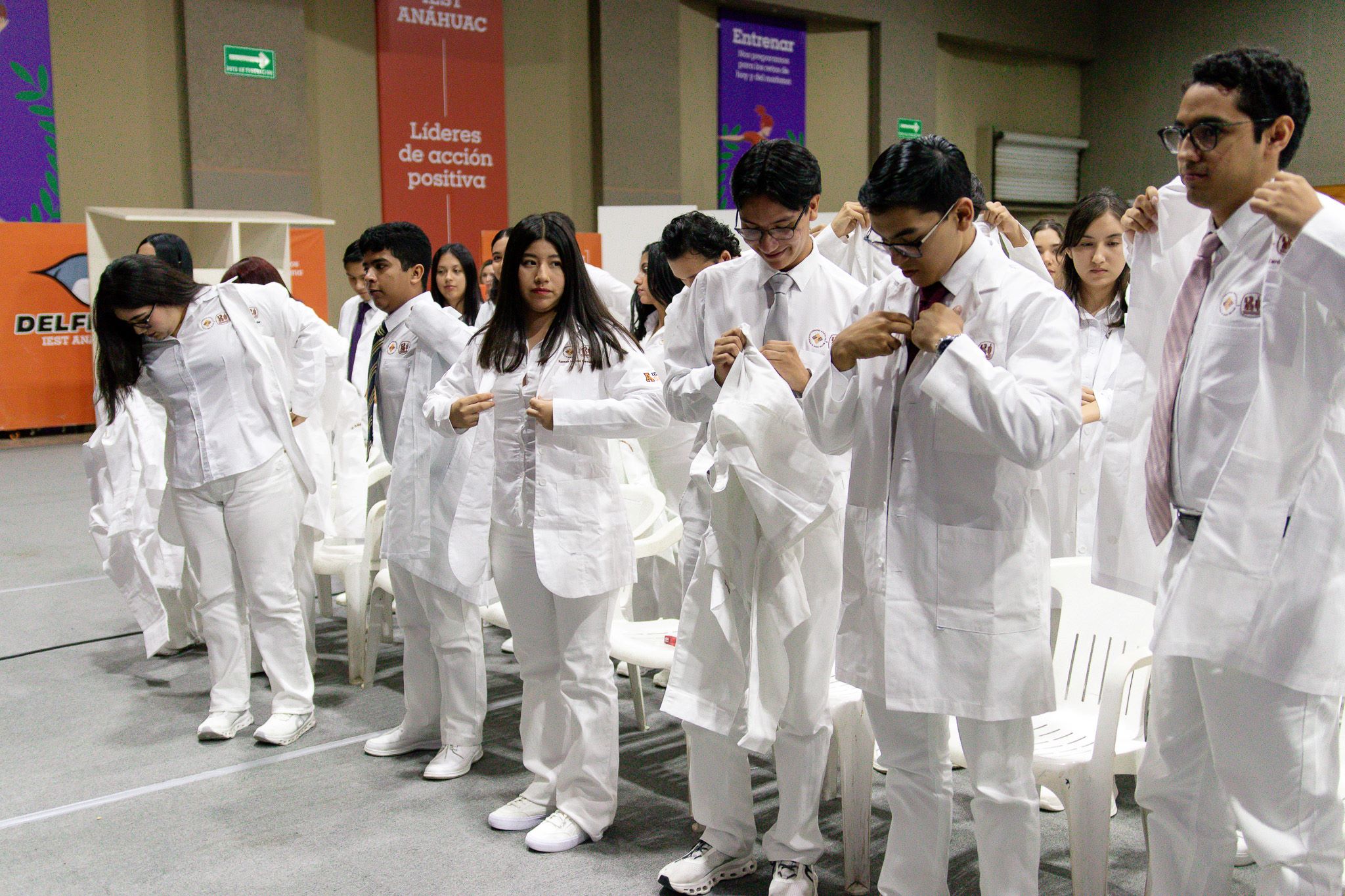 Alumnos de primer semestre de Medicina, colocándose la bata blanca.