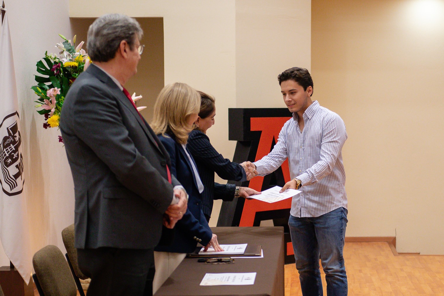 Joven de licenciatura recoge su diploma de excelencia. Septiembre 2026.