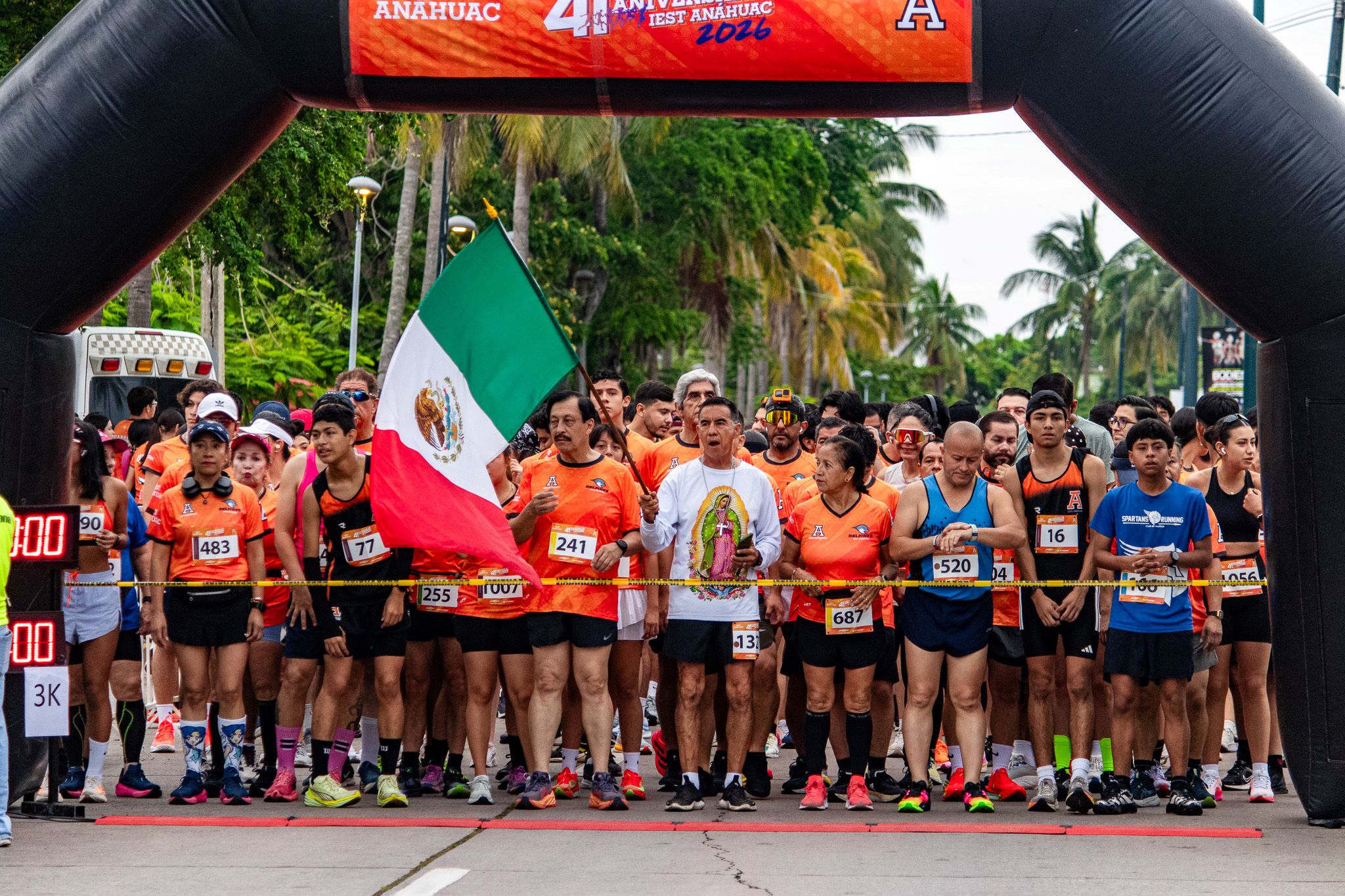 Aspecto de los participantes de la carrera de aniversario, antes de empezar. Hay un corredor muy guadalupano al centro de la imagen.