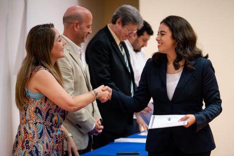 Alumna recibe diploma de Gastronomía y saluda a Mónica Violante.