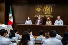 Presidium ante un cadáver anónimo, este último cubierto de una sábana blanca.