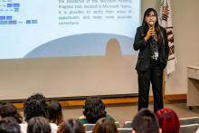 Maestra vestida de negro, de apariencia asiática, explicando algo en el auditorio C.P. Jesús Rodríguez.