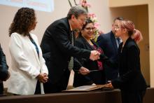 Basilio entregando reconocimiento a una alumna de universidad.