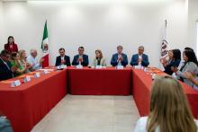 Autoridades aplauden, sentadas en la Sala de Juntas de la Rectoría, en compañía de prestadores de servicio social.