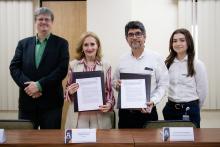 La Rectora y el representante de ORBIA sostienen el convenio que firmaron.