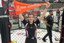 Alumna de arquitectura, ganadora de Torneo de Artes Marciales Mixtas en Córdoba Veracruz, agitando un banderín.