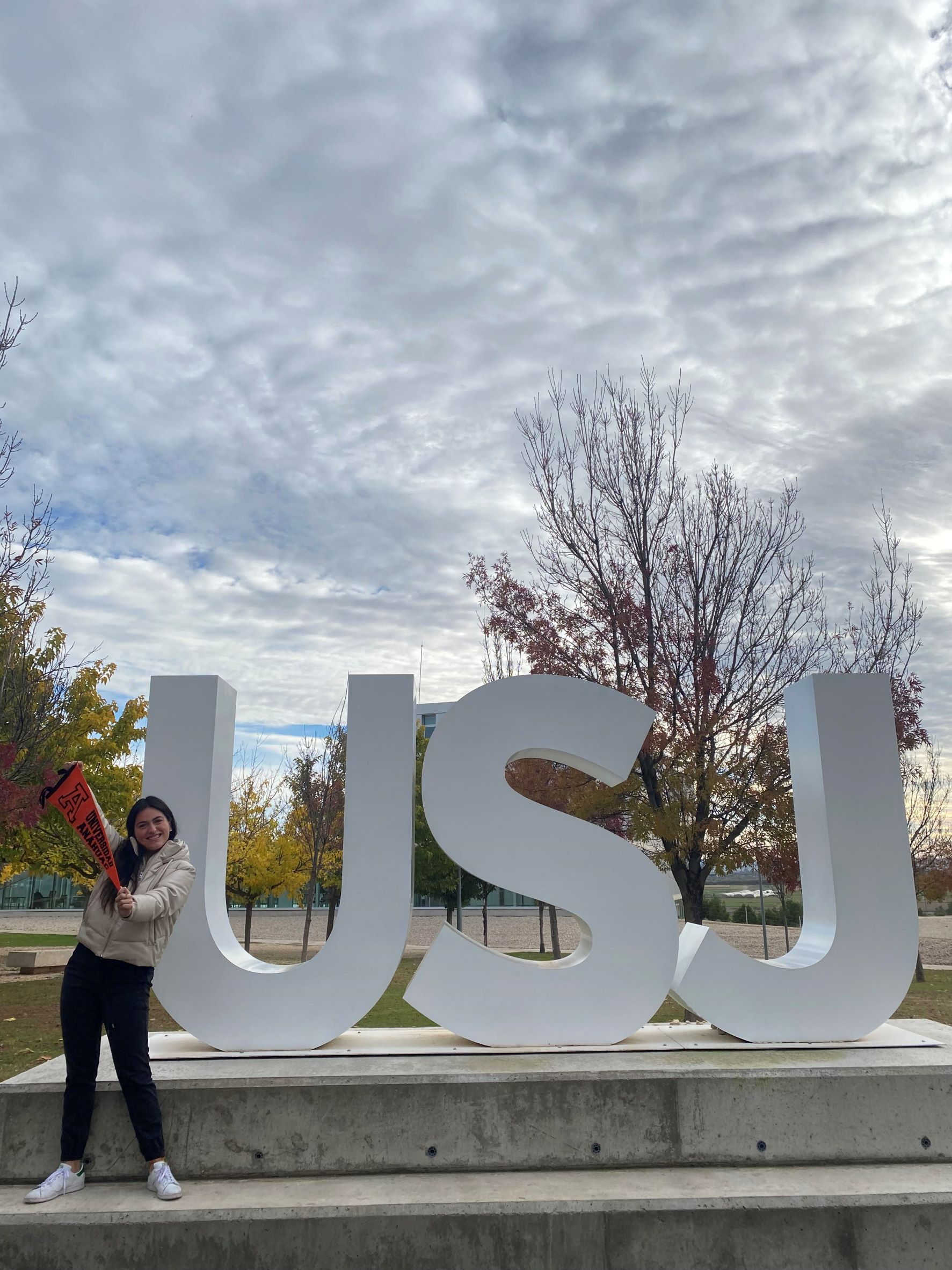 Cristina con el banderín Anáhuac en su Universidad de intercambio