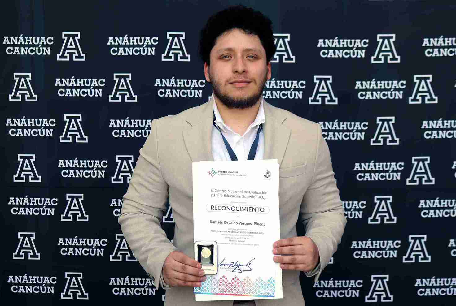 "Ramsés Osvaldo Vásquez Pineda sosteniendo su Reconocimiento de Excelencia Ceneval frente a un fondo de la Universidad Anáhuac Cancún"